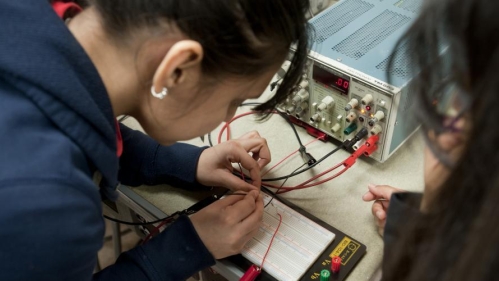 Close-up shot of students working in electrical engineering lab.
