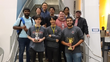 10 Rutgers students hold trophies won during a competition