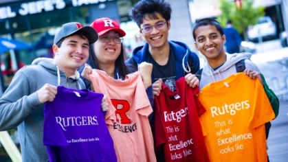 Five students holdingRutgers  t shirts in a variety of colors.