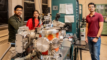 2 male and 1 female university students pose in an engineering lab