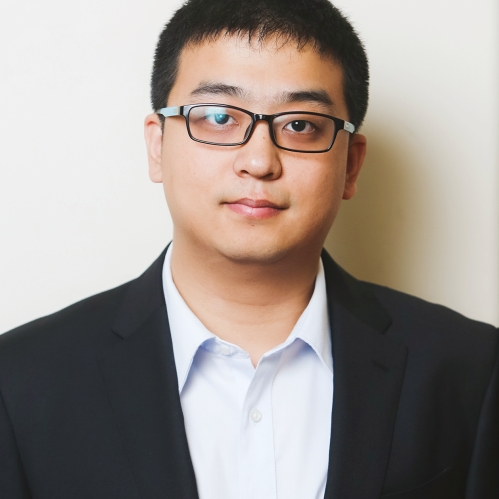 Head shot of Asian male with short black hair, eyeglasses wearing a black suit jacket with a white button down shirt.