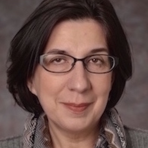 Head shot of woman with brown hair and eyeglasses.