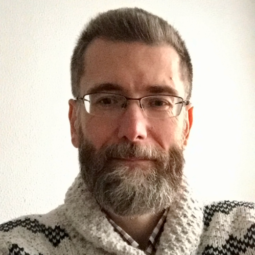 Head shot of male with short hair, full beard and eyeglasses.