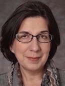Head shot of woman with brown hair and eyeglasses.