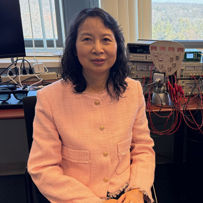 Woman in a peach jacket sits in her lab