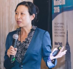 Yingying Chen speaking while holding a microphone during a presentation