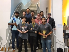 10 Rutgers students hold trophies won during a competition