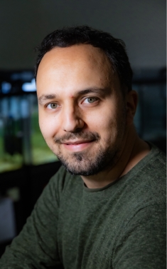 Headshot of male with short hair a beard and a moustache.